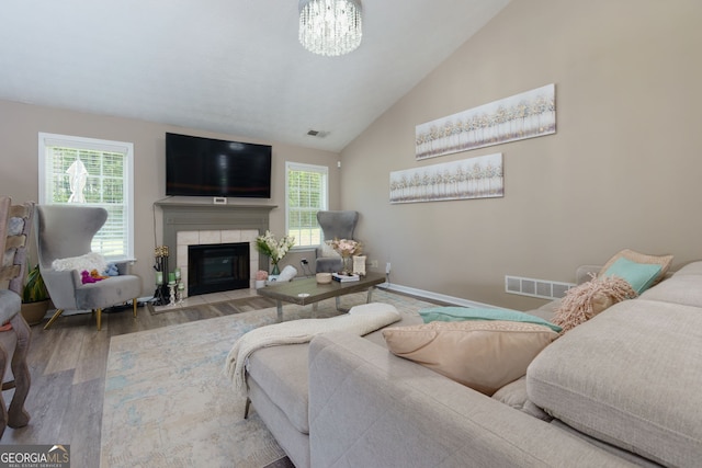 101 Javay Ct, Villa Rica, GA 30180 - living area with wood finished floors, a tile fireplace, a chandelier, and high vaulted ceiling