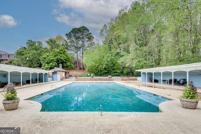 pool with a patio area, a pergola, and fence
