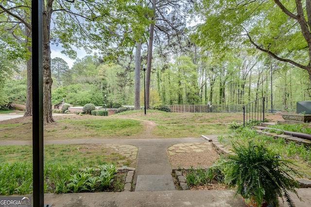 view of community featuring a yard and fence