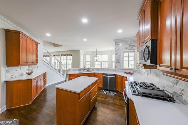 kitchen with a peninsula, brown cabinets, backsplash, and stainless steel appliances