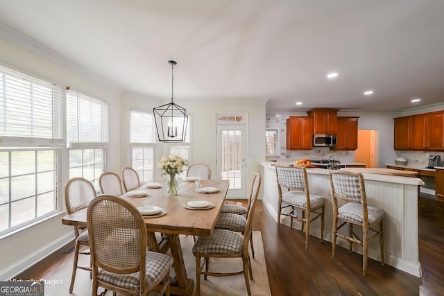 dining area featuring dark wood finished floors, ornamental molding, and a healthy amount of sunlight