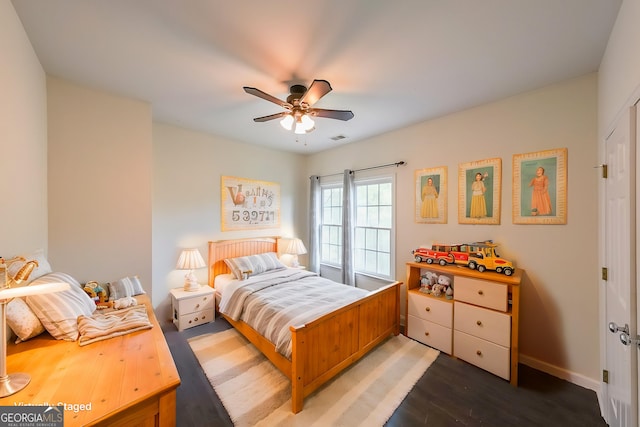 bedroom with wood finished floors, baseboards, a ceiling fan, and visible vents