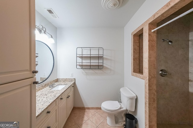 full bathroom with vanity, tile patterned flooring, toilet, tiled shower, and visible vents