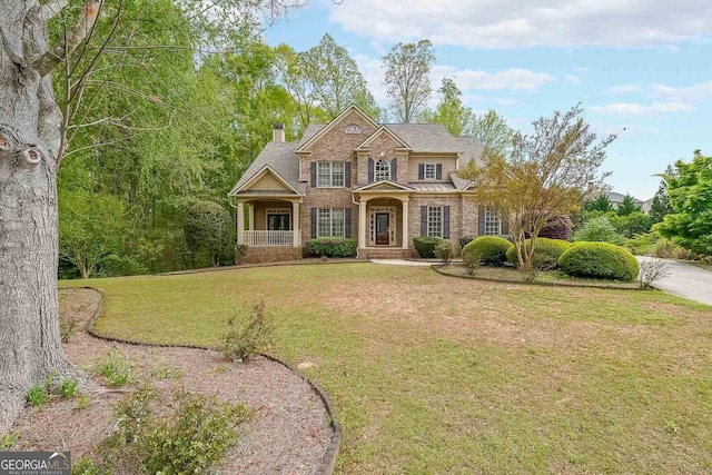view of front of house with a front yard and brick siding