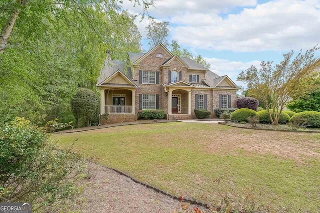 craftsman house with a front yard and brick siding