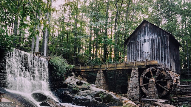 view of outdoor structure with a view of trees and an outbuilding
