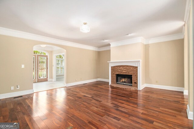 110 Kylemore Pass, Tyrone, GA 30290 - unfurnished living room featuring arched walkways, wood finished floors, ornamental molding, a fireplace, and baseboards