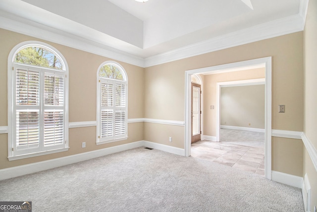 unfurnished room with light colored carpet, healthy amount of natural light, ornamental molding, baseboards, and light tile patterned flooring