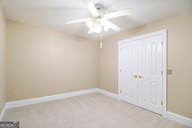unfurnished bedroom featuring carpet, a closet, baseboards, and ceiling fan