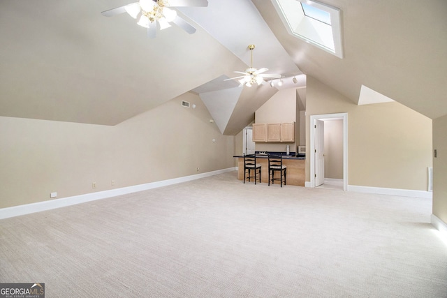 additional living space with a ceiling fan, lofted ceiling, a skylight, light carpet, and baseboards