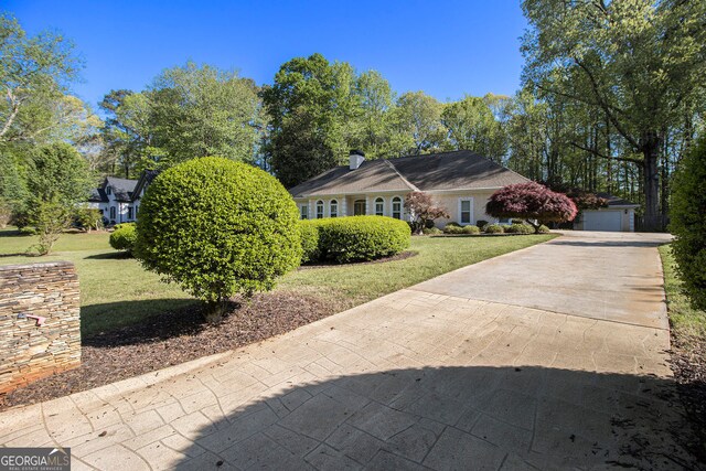 110 Kylemore Pass, Tyrone, GA 30290 - view of front facade featuring a front yard, concrete driveway, a garage, and a chimney