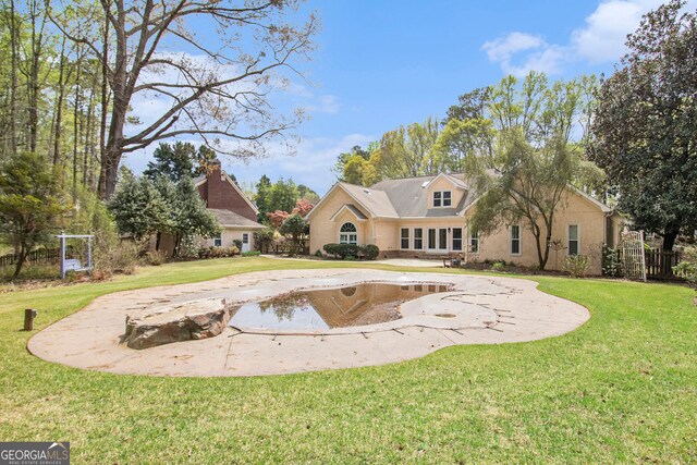 rear view of house featuring stucco siding and curved driveway