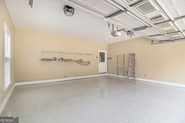 garage with a garage door opener and baseboards