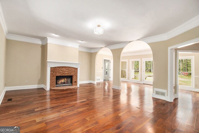 110 Kylemore Pass, Tyrone, GA 30290 - unfurnished living room with arched walkways, hardwood / wood-style floors, crown molding, baseboards, and a fireplace