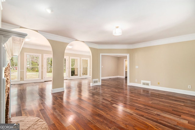 unfurnished living room with dark wood finished floors, baseboards, and ornamental molding