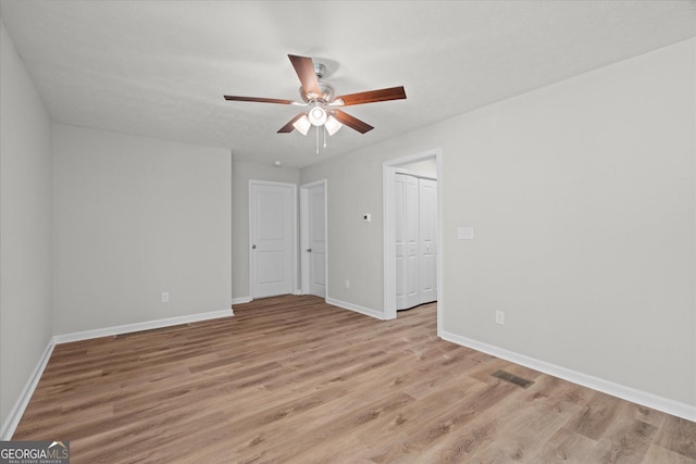 unfurnished bedroom with light wood-style flooring, baseboards, visible vents, and a ceiling fan