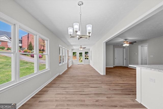 313 Ellenwood Dr, Bowdon, GA 30108 - unfurnished dining area with ceiling fan, a chandelier, light wood finished floors, and baseboards