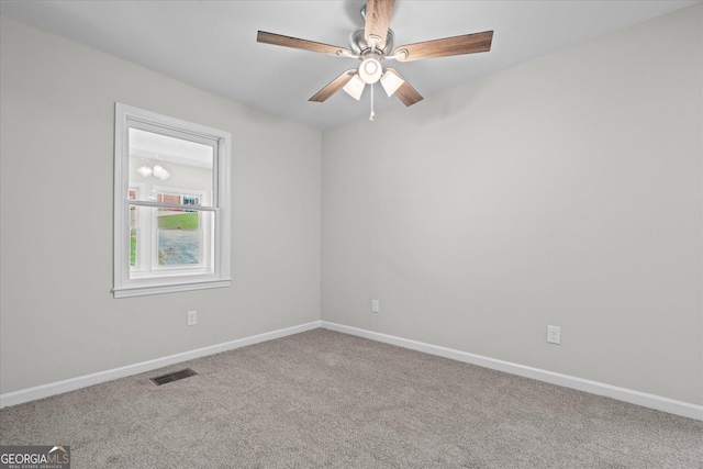 carpeted spare room featuring visible vents, baseboards, and ceiling fan