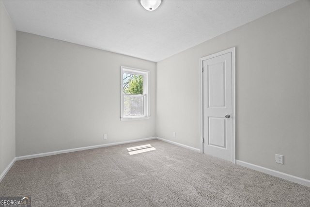 carpeted spare room with baseboards