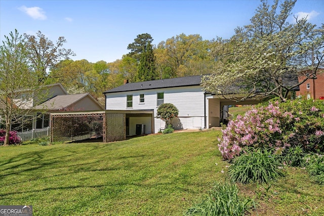 rear view of house featuring central air condition unit, a yard, and fence