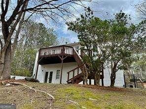 back of house with a wooden deck and stairs