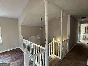 hallway featuring baseboards and an upstairs landing