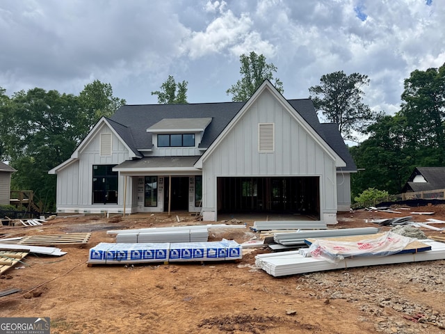 rear view of property featuring a shingled roof and board and batten siding