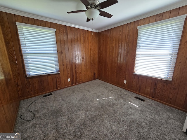 carpeted spare room featuring visible vents, baseboards, and a ceiling fan