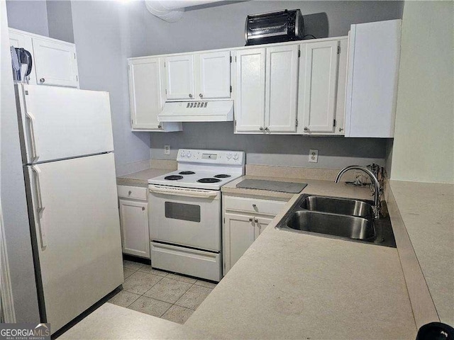 kitchen featuring white appliances, white cabinets, under cabinet range hood, light countertops, and a sink