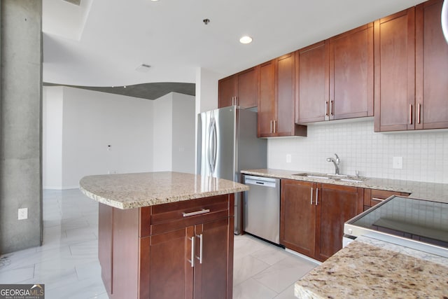 kitchen with light stone counters, backsplash, appliances with stainless steel finishes, marble finish floor, and a sink
