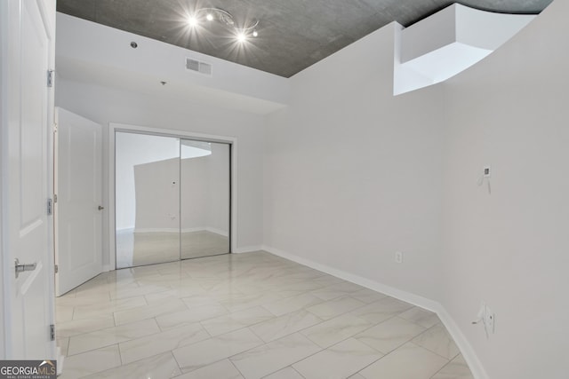 unfurnished bedroom with visible vents, baseboards, a closet, and marble finish floor