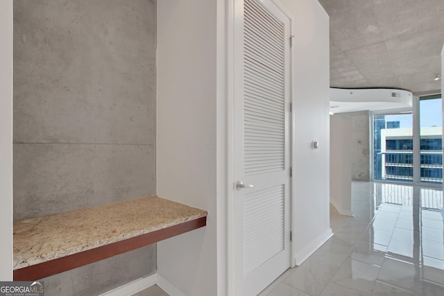 hallway featuring floor to ceiling windows and baseboards