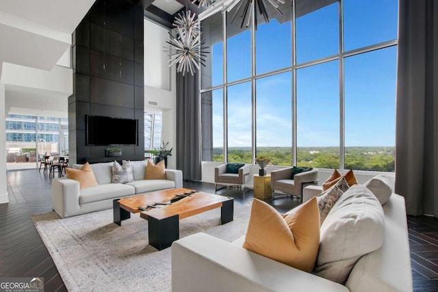 living room with a wealth of natural light, a high ceiling, and dark wood finished floors