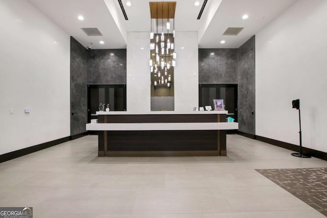 bathroom with visible vents, double vanity, and an accent wall