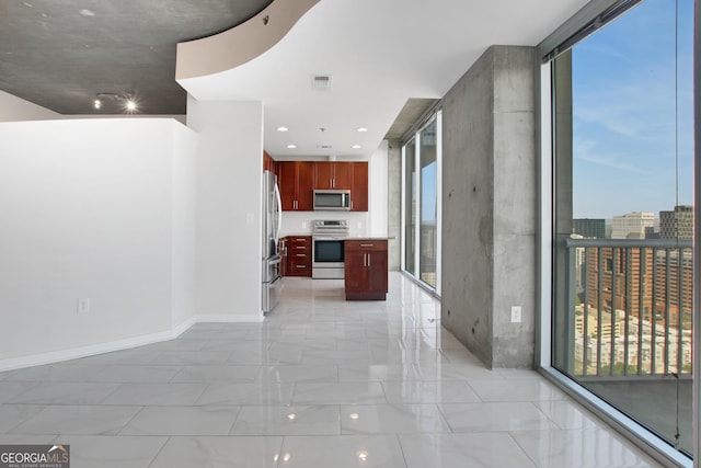 hallway featuring a healthy amount of sunlight, baseboards, visible vents, and expansive windows