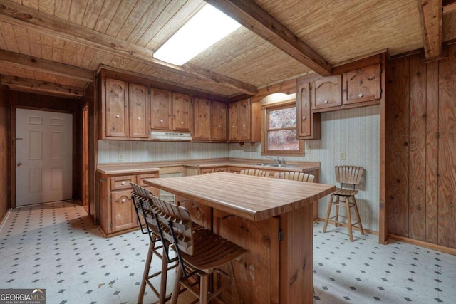 2479 Plum Orchard Rd Unit 1 & 2, Clayton, GA 30525 - kitchen featuring a wooden ceiling with exposed beams, under cabinet range hood, light flooring, brown cabinetry, and wood counters