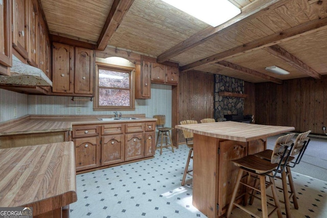 2479 Plum Orchard Rd Unit 1 & 2, Clayton, GA 30525 - kitchen with a wooden ceiling with exposed beams, wood walls, brown cabinets, butcher block countertops, and a breakfast bar area