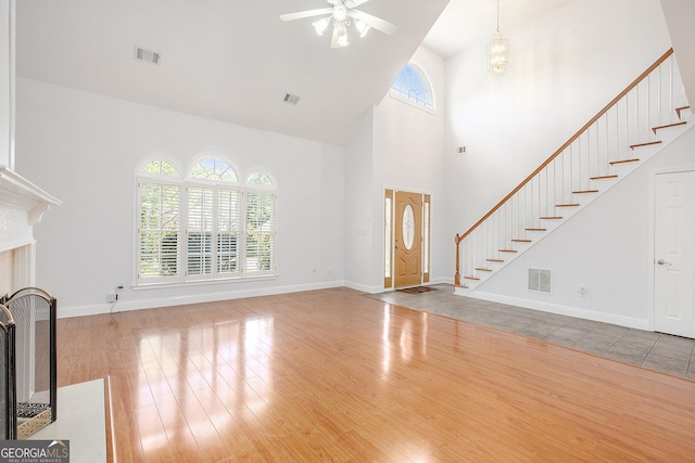 4505 Lakefield Bnd, Berkeley Lake, GA 30096 - unfurnished living room with wood finished floors, high vaulted ceiling, ceiling fan, and stairs