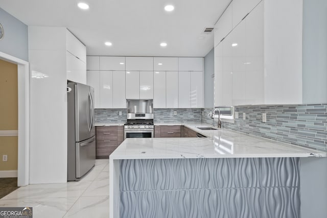 kitchen with appliances with stainless steel finishes, modern cabinets, a sink, a peninsula, and recessed lighting