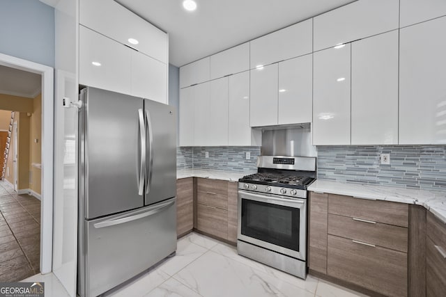 kitchen featuring appliances with stainless steel finishes, modern cabinets, white cabinetry, ornamental molding, and recessed lighting