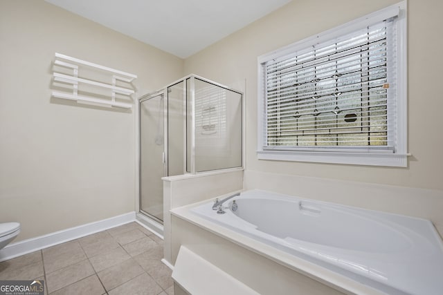 bathroom with a stall shower, tile patterned floors, a bath, baseboards, and toilet