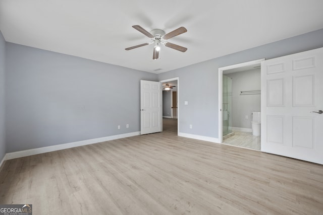 unfurnished bedroom with wood finished floors, baseboards, connected bathroom, and ceiling fan
