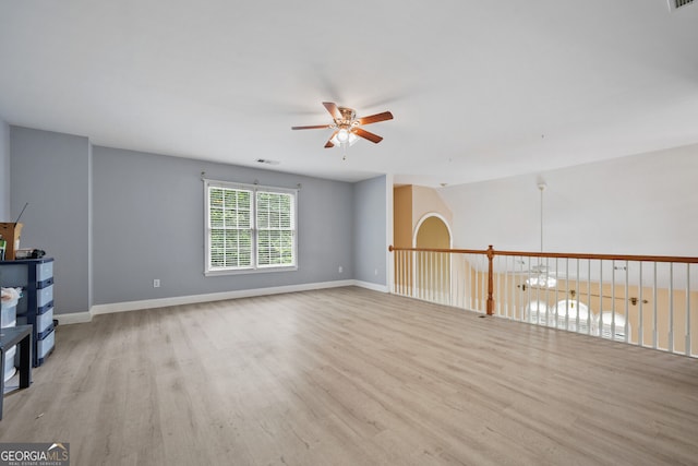 empty room with a ceiling fan, wood finished floors, and baseboards