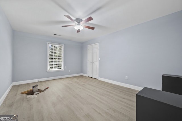 empty room with ceiling fan, wood finished floors, and baseboards