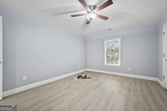 spare room featuring wood finished floors, baseboards, and ceiling fan