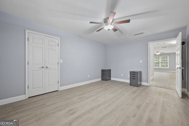 unfurnished bedroom featuring light wood-style floors, baseboards, and a ceiling fan