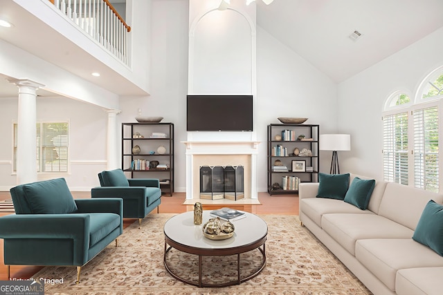 4505 Lakefield Bnd, Berkeley Lake, GA 30096 - living area with high vaulted ceiling, decorative columns, wood finished floors, a fireplace with flush hearth, and recessed lighting