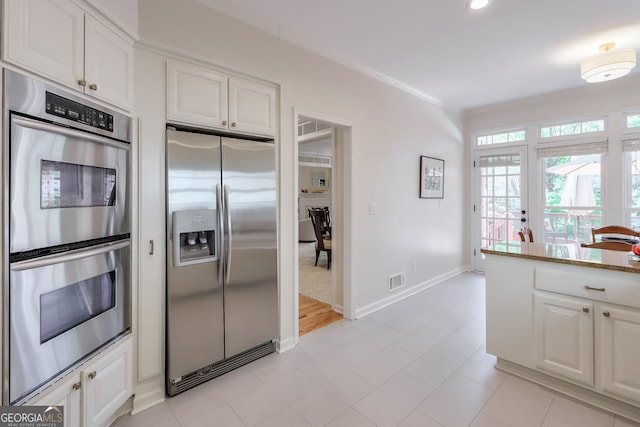 kitchen featuring stainless steel appliances, white cabinets, crown molding, baseboards, and stone countertops