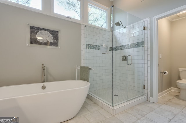 bathroom featuring a stall shower, toilet, marble finish floors, ornamental molding, and a freestanding tub