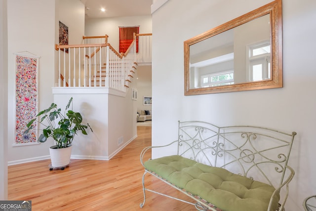 hall with wood finished floors, baseboards, and stairway